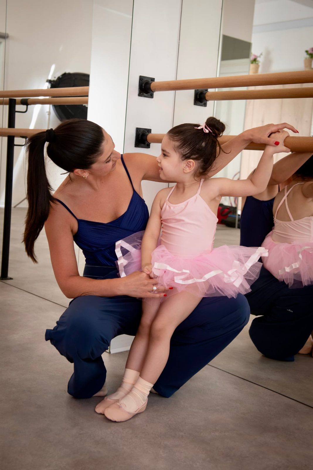Little ballerina at the barre with her teacher